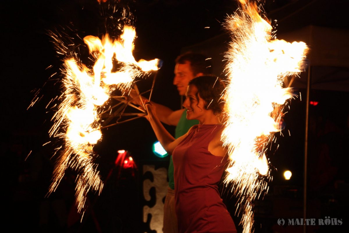 Woman performing with fire fans during the Berlin juggling convention